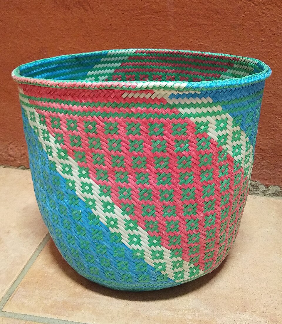 A colorful woven basket with pink, green, and blue patterns