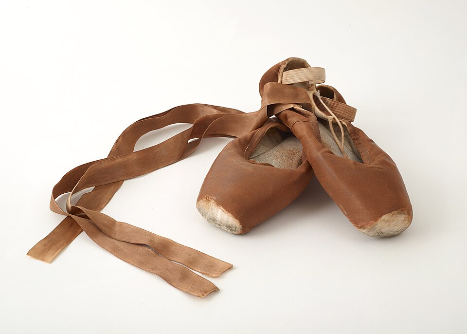 A pair of ballet pointe shoes with satin ribbons