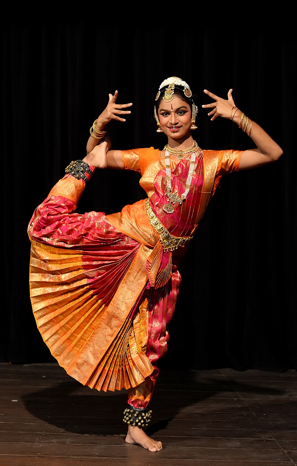 Dancers performing Bharatanatyam, a traditional Indian dance, in colorful costumes on stage