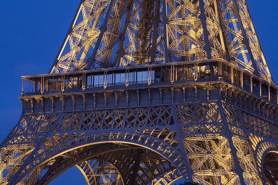 La Torre Eiffel iluminada por la noche mostrando su estructura de hierro