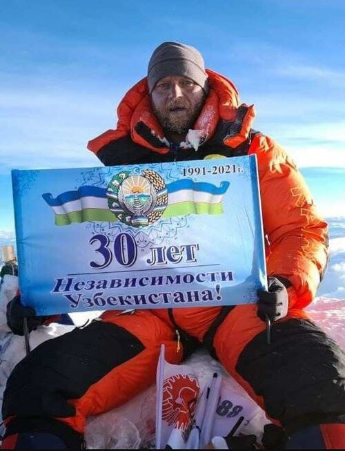 一位登山者站在珠穆朗玛峰积雪的山顶，这是地球上最高的山峰